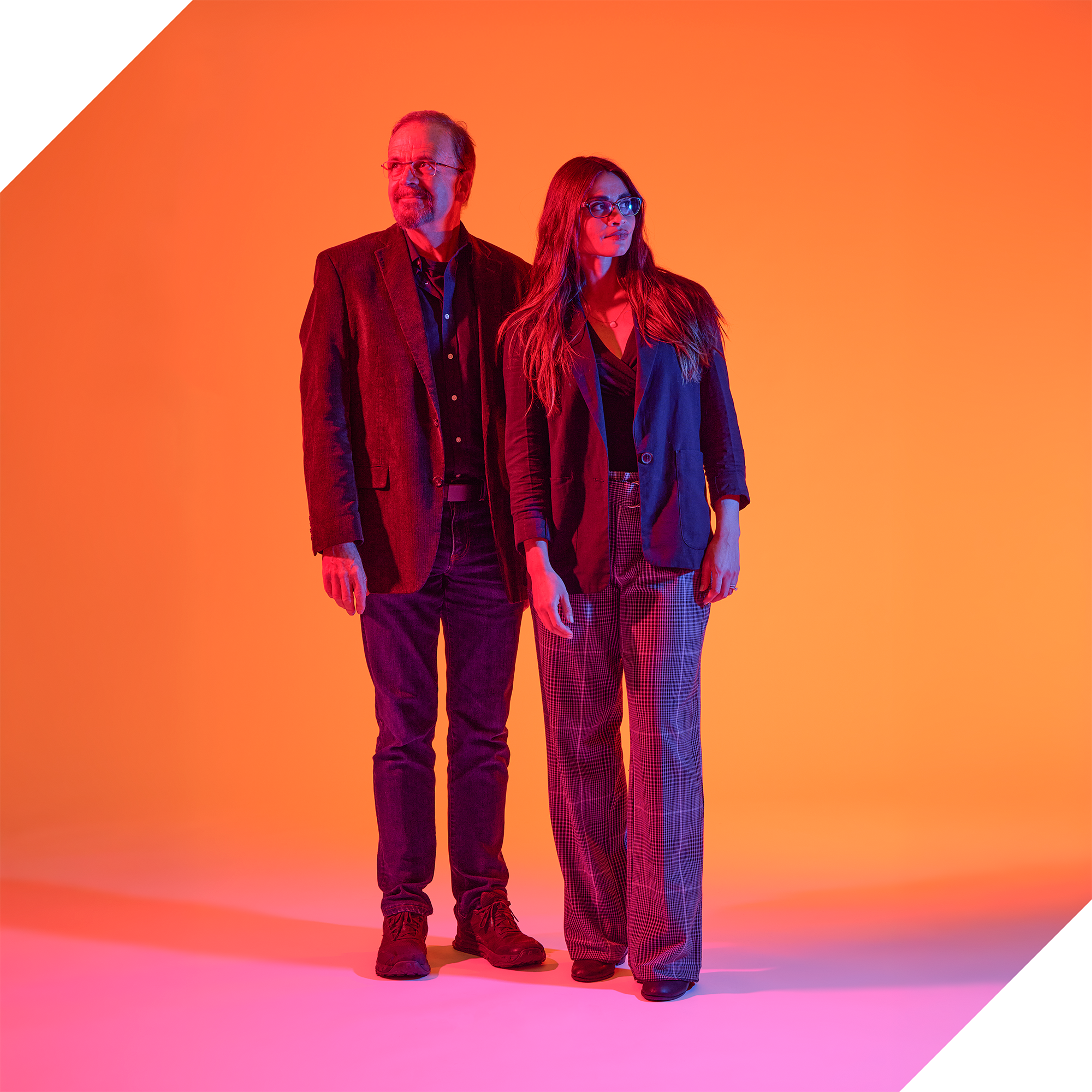 Jordan Ochs (FYE Program Director), and Bradley Wright (Professor of Sociology) stand tall against a gradient backdrop of orange and pink