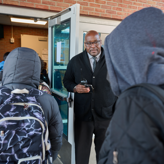 Lewis greets children entering the school.