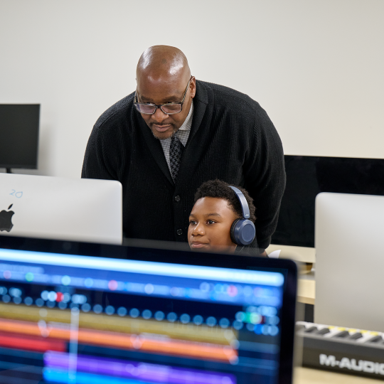 Lewis helps a young student in the school's computer lab.