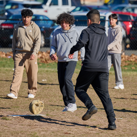 Children play a game of soccer outside the school.