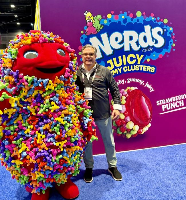 Guidotti poses next to Nerds Gummy Clusters mascot.