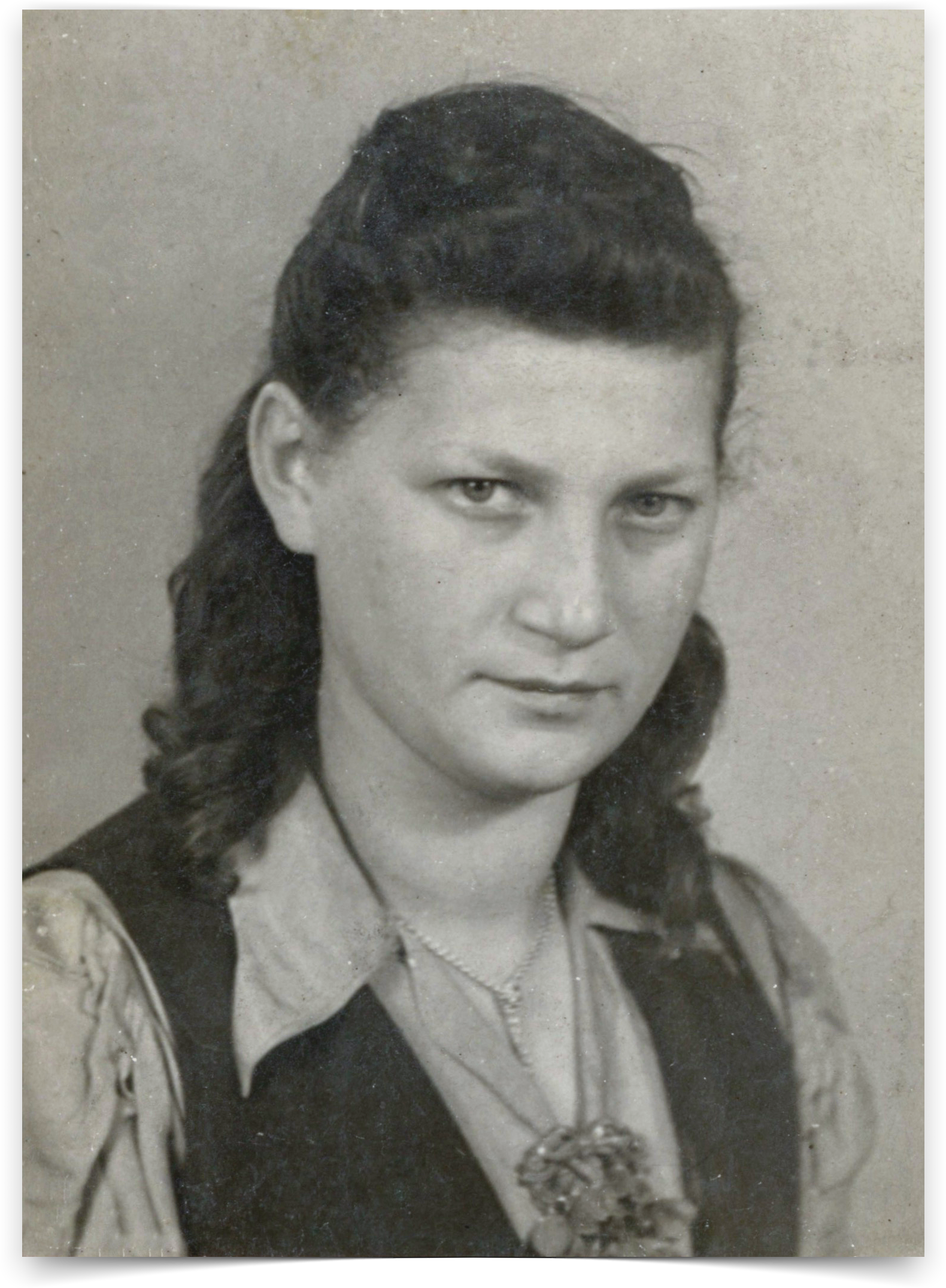 A vintage photo of a woman, Sally, wearing a black vest and a necklace.