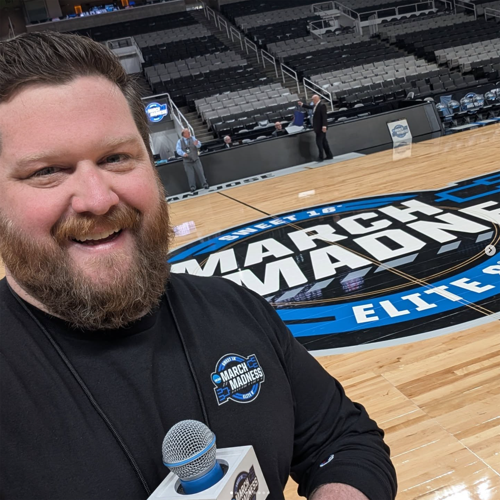 Geary smiles for the camera in front of a basketball court.