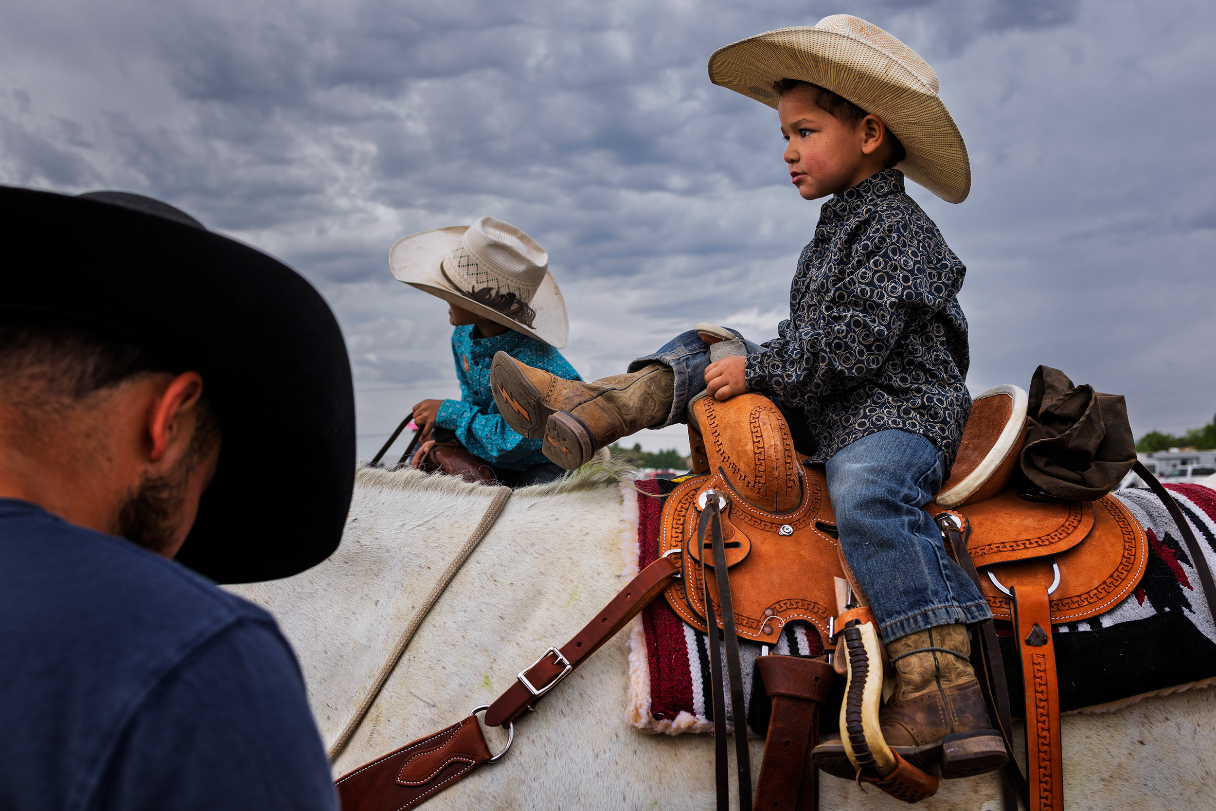 Matthew Sanchez, 3, of Cuba, New Mexico, prepares to compete in barrel racing at a rodeo in Chama. His brother Joseph, 7, waits nearby on horseback.