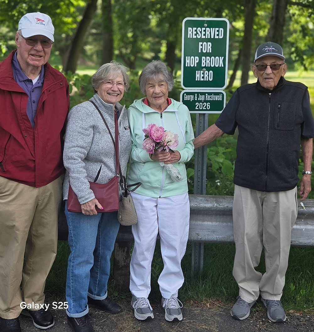 George Rackowski and Joan Rackowski pose in front of a sign that reads "Reserved for Hop Brook Hero".