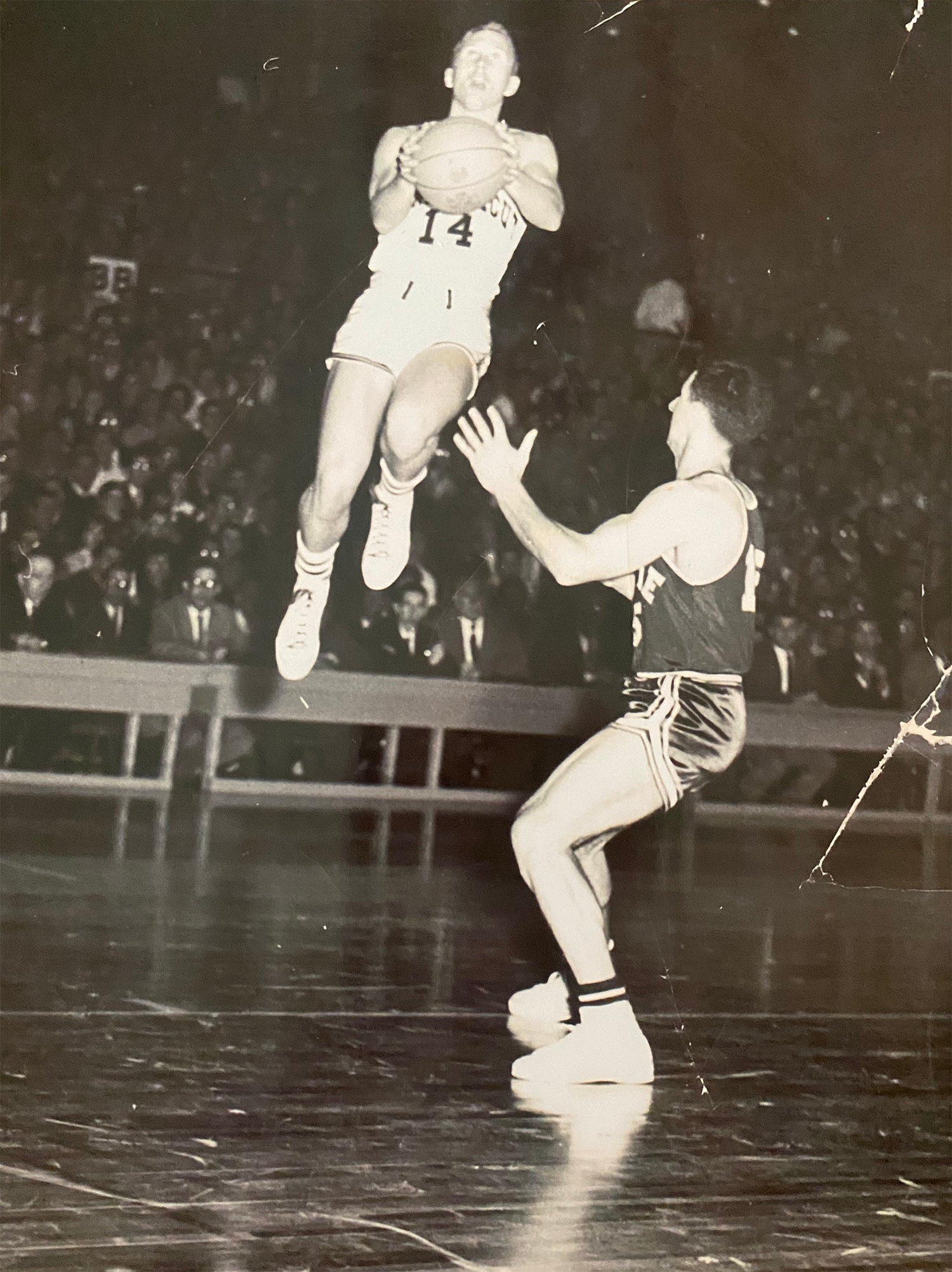Carlson playing against Maine in the old field house. He is jumping high into the air.