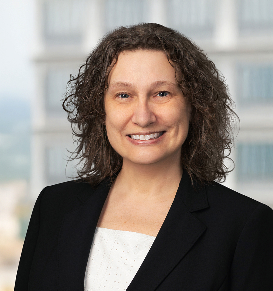 A photo portrait of Nancy Kennedy, smiling for the camera wearing a black blazer.