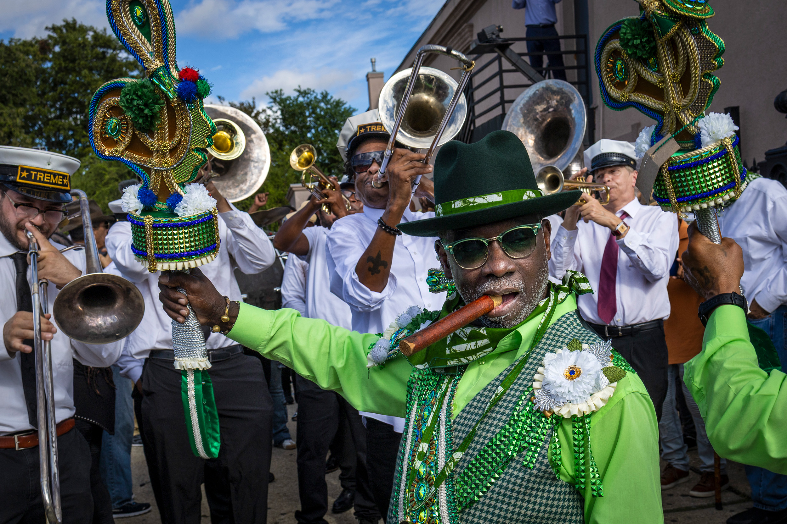 Band in green and white, blows their instruments on the Second Line 7th Ward, New Orleans, Louisiana