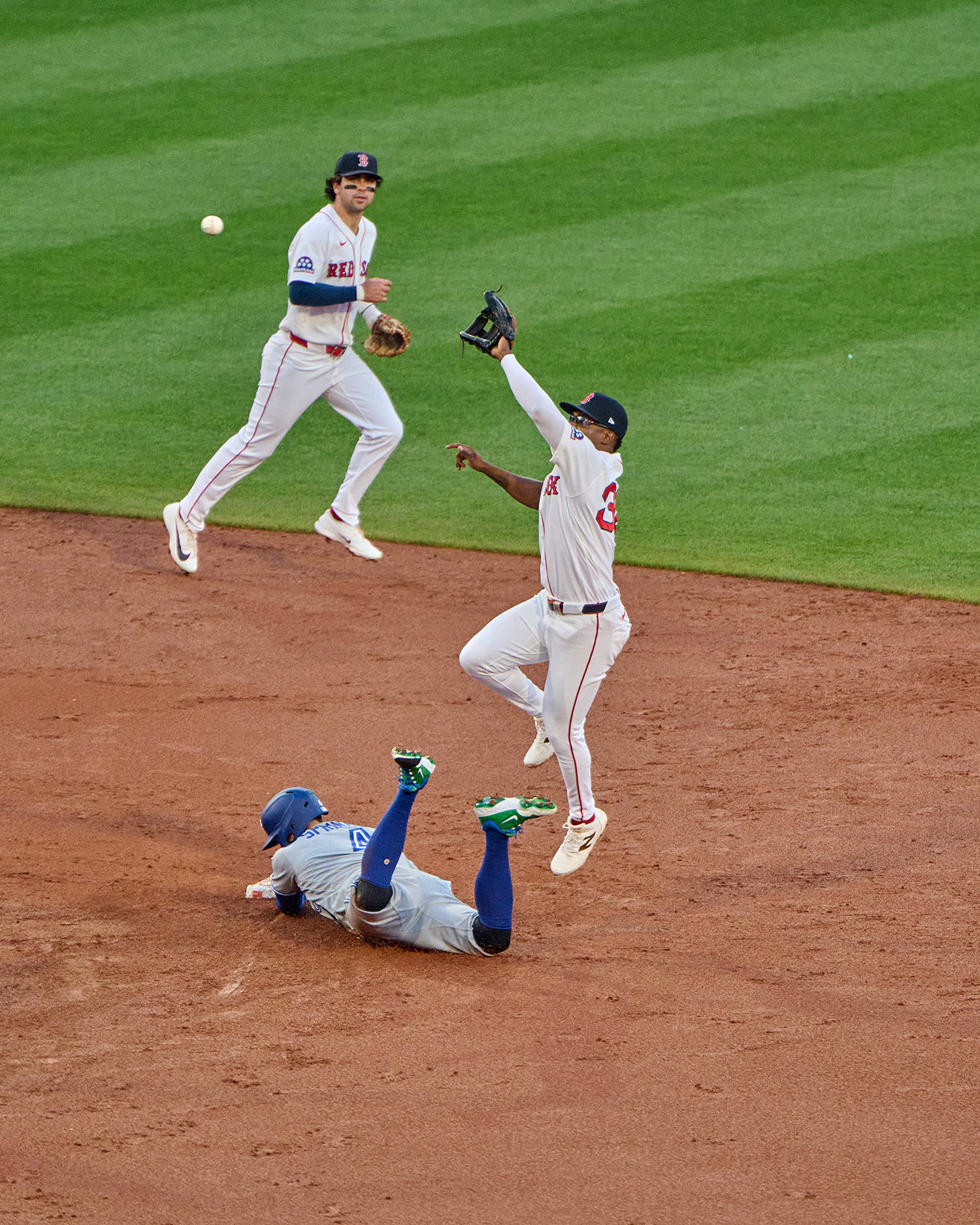 Springer slides into a base before a Red Sox plater can catch a baseball.