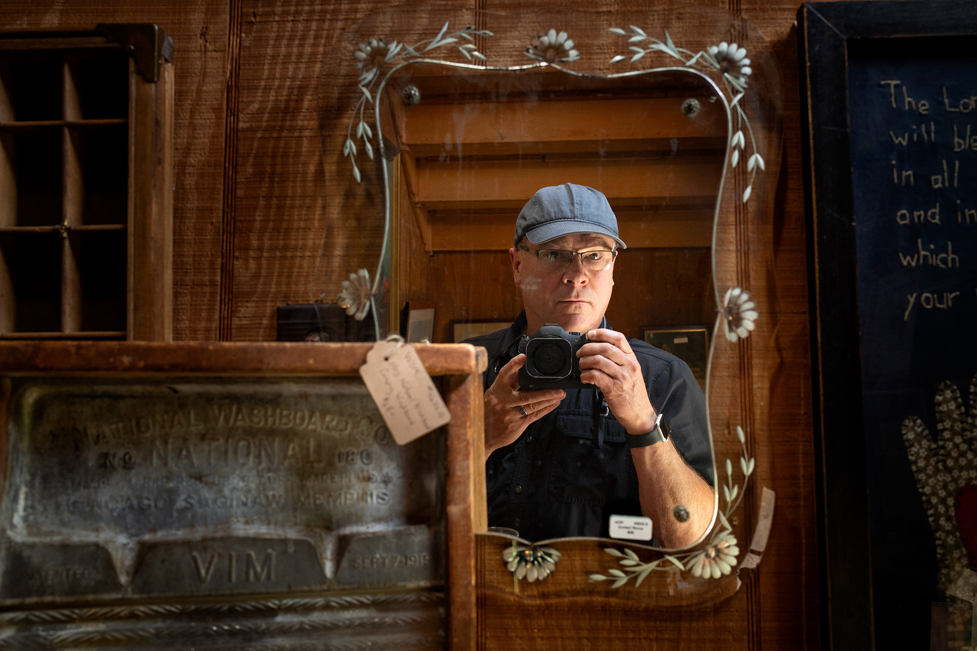 Self Portrait Steven G. Smith where he points a camera at a vintage mirror