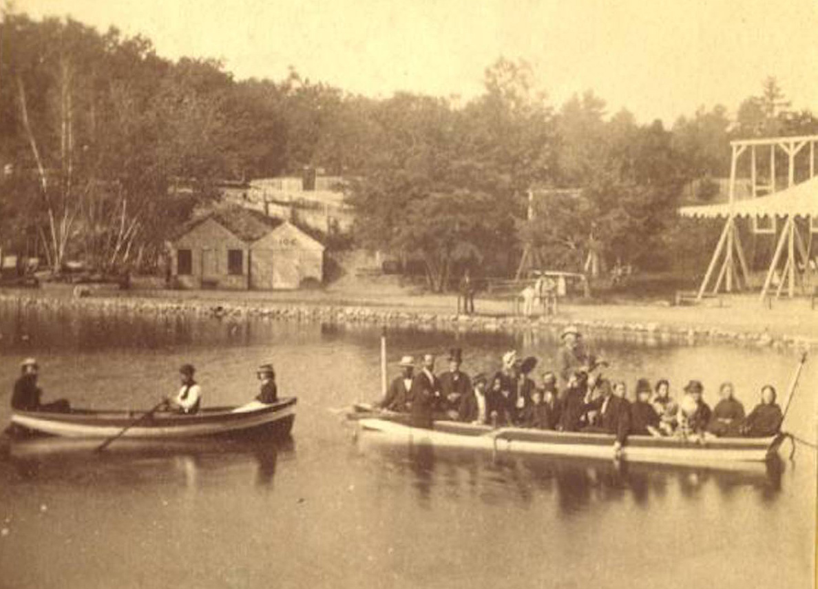 A vintage photo of groups boating at the amusement park, looking west over Ice Fort Cove.