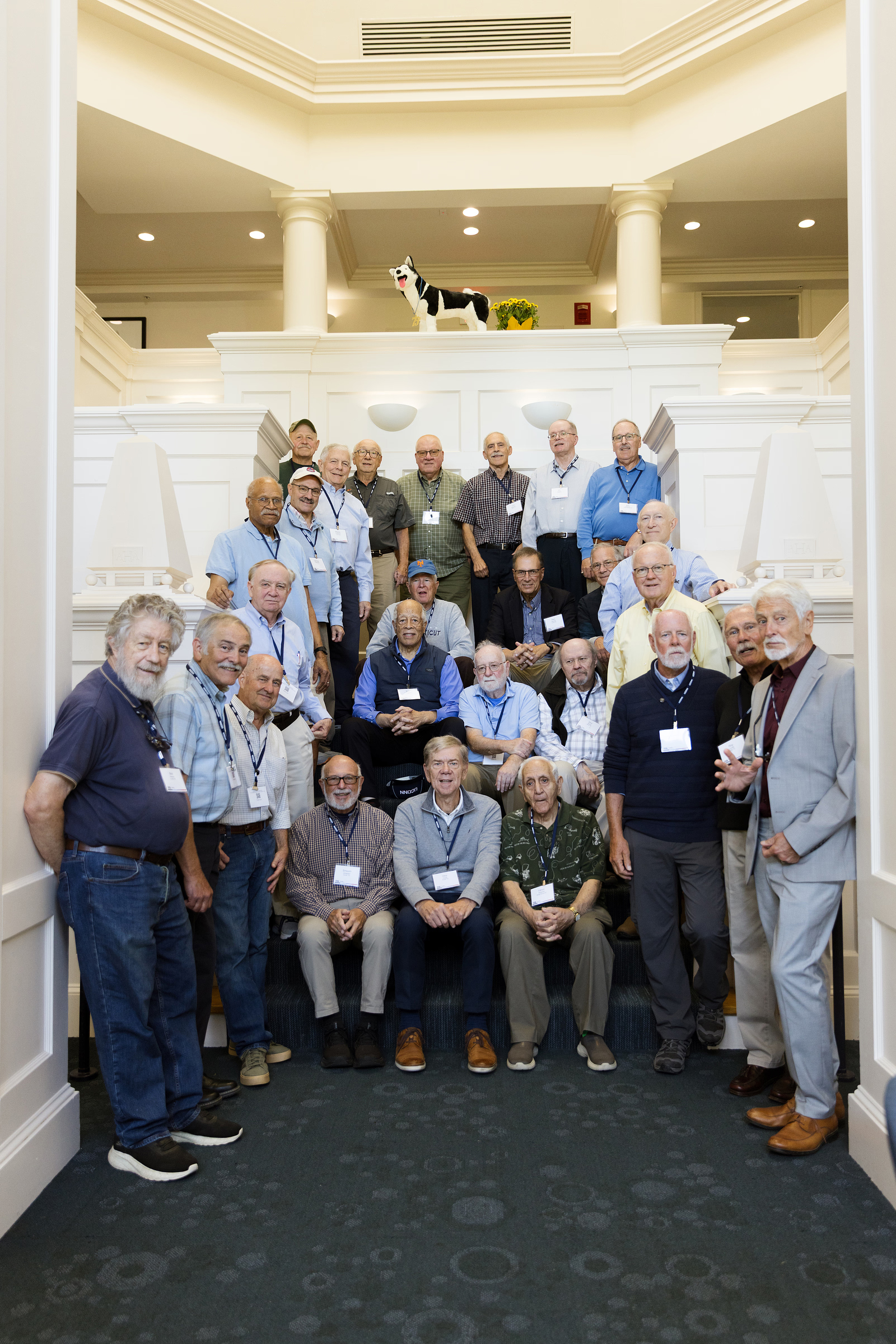 Alumni from Beta Sigma Gamma gathered for a photo at the entrance of the Graduate Hotel, at Storrs