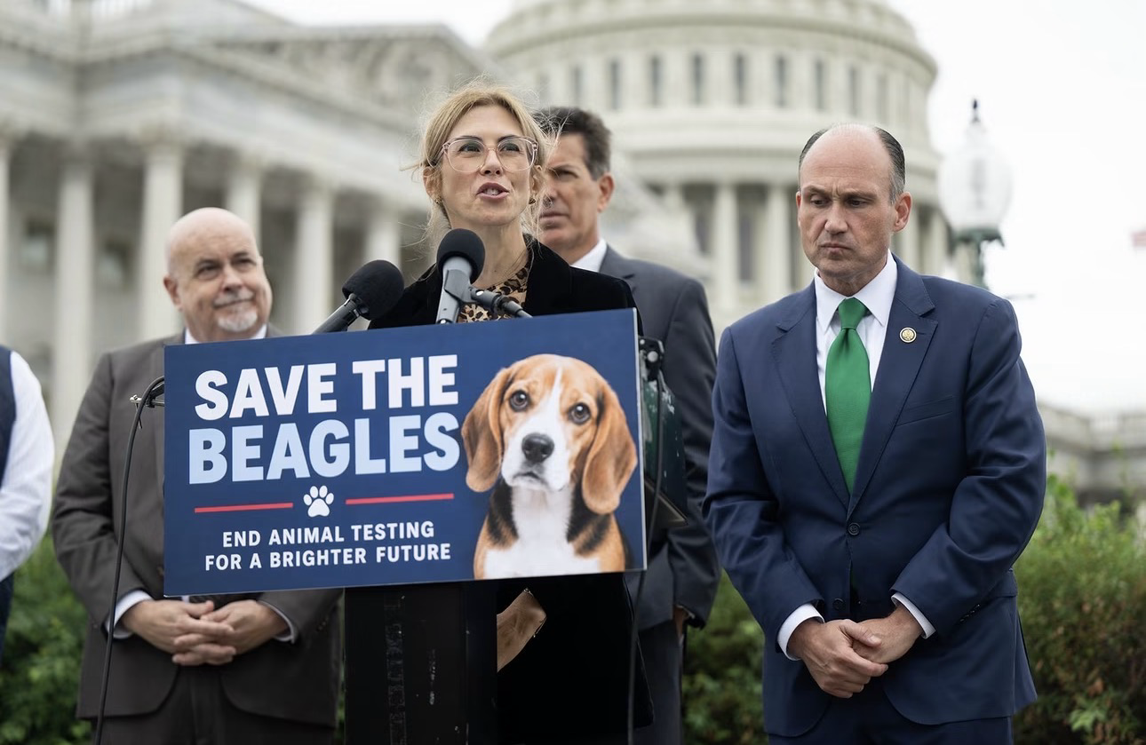 Stacy Lopresti-Goodman speaks infront of podium showcasing a sign advocating for animal rights in Washington D.C.